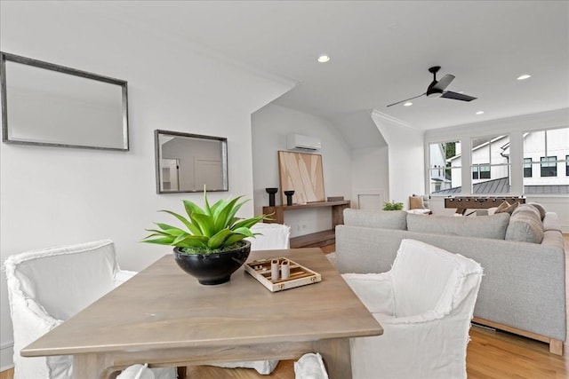 dining space with ceiling fan, light hardwood / wood-style floors, a wall mounted air conditioner, and crown molding