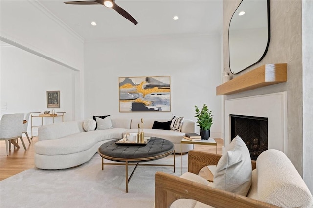 living room featuring ceiling fan, crown molding, and wood-type flooring