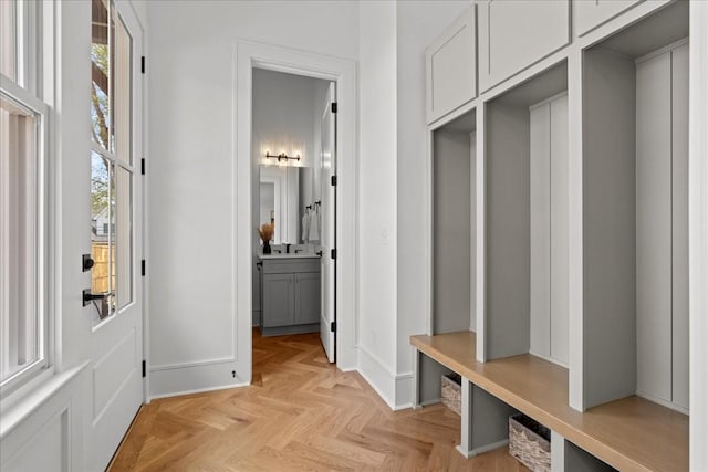 mudroom featuring light parquet flooring and a healthy amount of sunlight