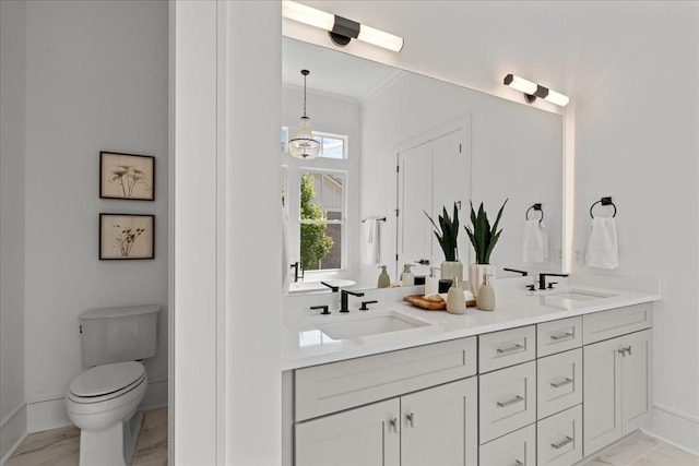 bathroom featuring toilet, vanity, and ornamental molding