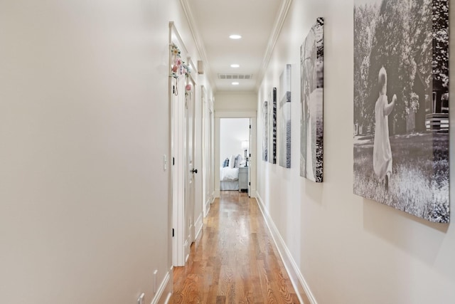 hall featuring light wood-type flooring and crown molding