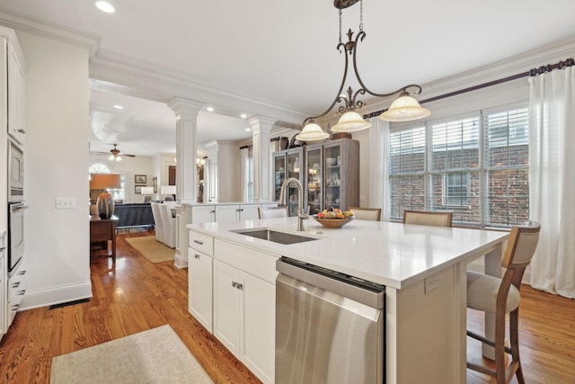 kitchen featuring a kitchen island with sink, appliances with stainless steel finishes, pendant lighting, white cabinets, and sink