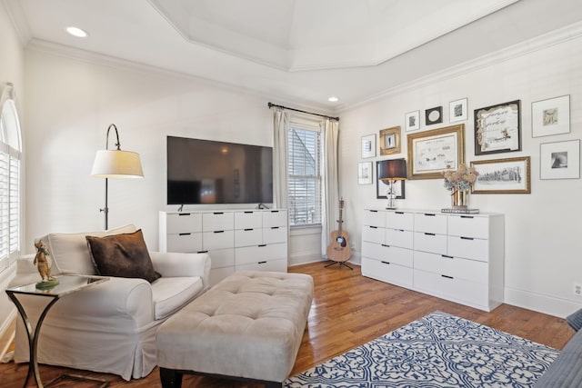 living room with a raised ceiling, crown molding, and hardwood / wood-style flooring