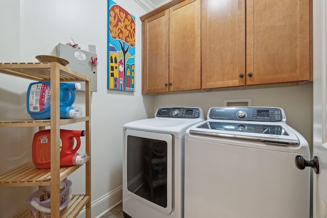 laundry room featuring cabinets and washer and clothes dryer