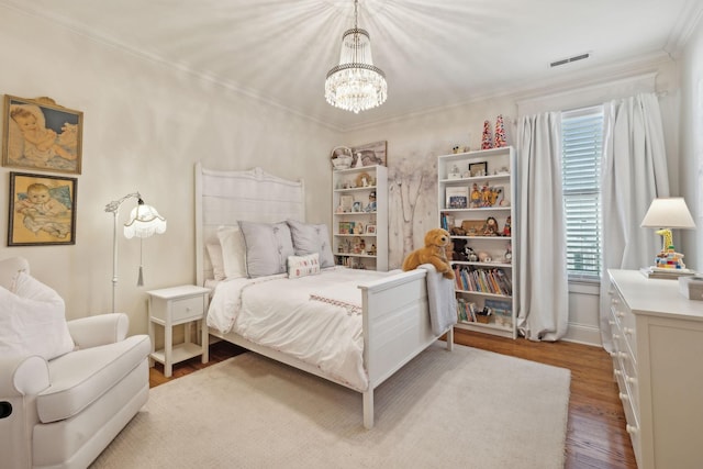 bedroom with a notable chandelier, hardwood / wood-style floors, and crown molding