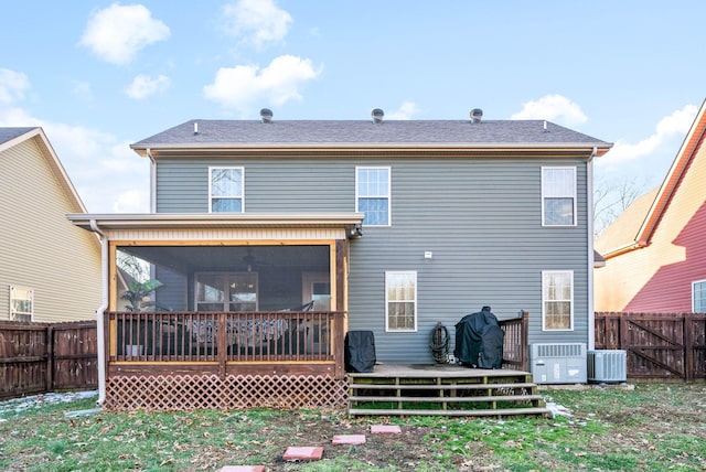 rear view of property with a lawn, central AC unit, a sunroom, and a wooden deck