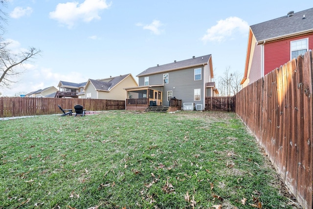 rear view of house featuring cooling unit and a yard