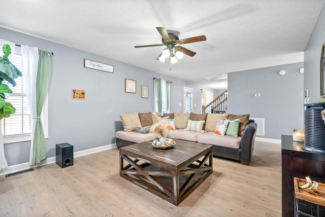 living room featuring a healthy amount of sunlight, ceiling fan, and light hardwood / wood-style flooring