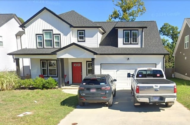 view of front of home with a porch, a front yard, and a garage