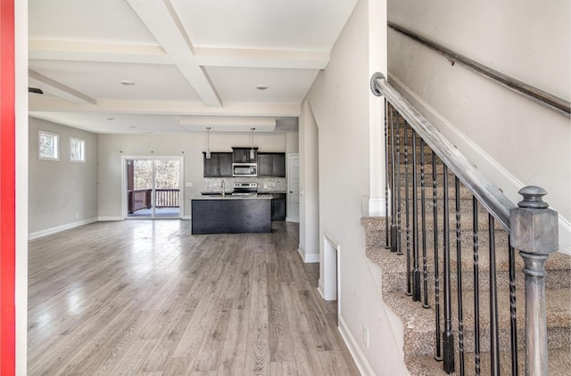 living room featuring beamed ceiling, wood-type flooring, and coffered ceiling