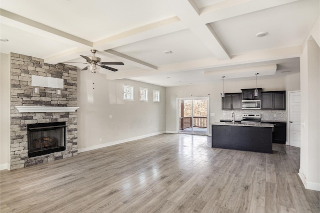 unfurnished living room featuring coffered ceiling, hardwood / wood-style flooring, beam ceiling, and a fireplace