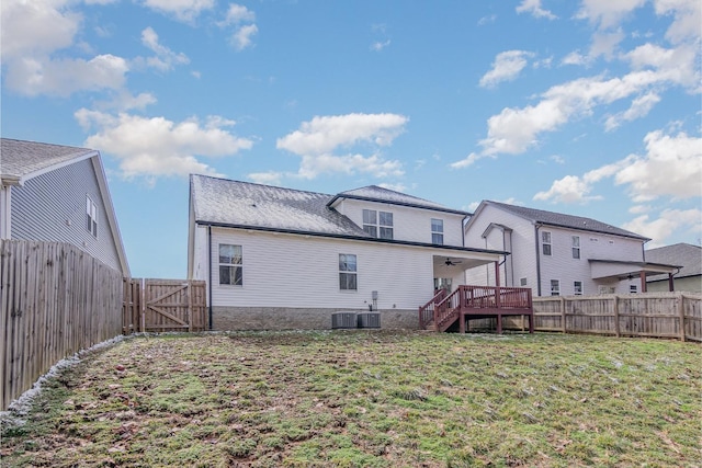 rear view of house with a yard, a wooden deck, and central AC unit