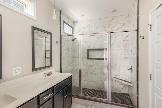 bathroom with a wealth of natural light, a shower with shower door, and vanity