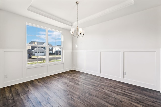 unfurnished dining area with dark hardwood / wood-style flooring, a chandelier, and a tray ceiling