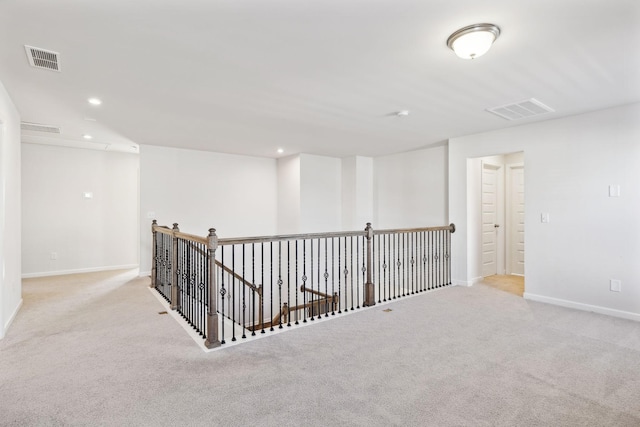 corridor featuring light colored carpet