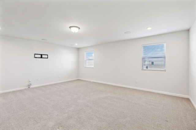 spare room featuring light colored carpet