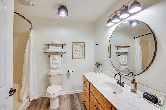 bathroom with wood-type flooring, walk in shower, vanity, and toilet