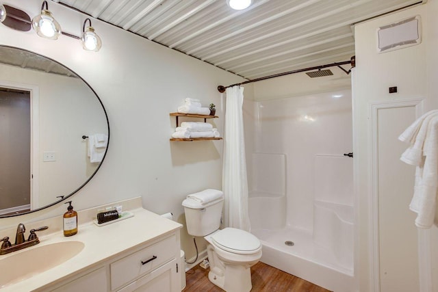 bathroom with toilet, vanity, a shower with curtain, and hardwood / wood-style floors