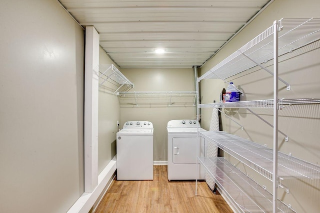 laundry room with washer and clothes dryer and light wood-type flooring