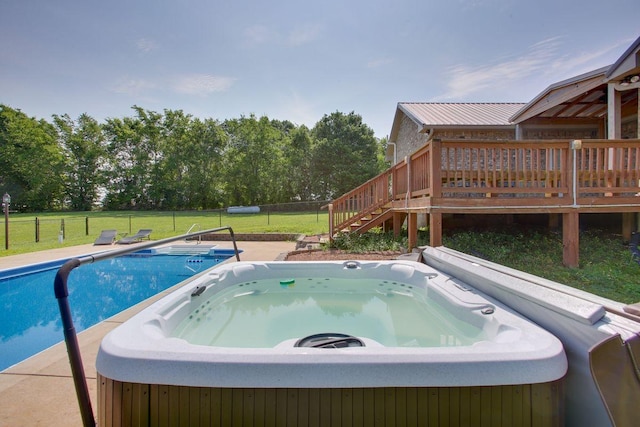 view of swimming pool featuring a deck, a hot tub, and a yard