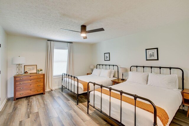 bedroom featuring ceiling fan, a textured ceiling, and wood-type flooring