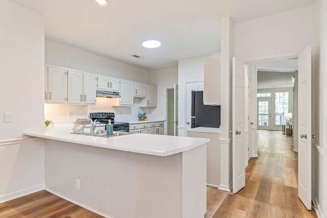 kitchen featuring white cabinets, french doors, light wood-type flooring, kitchen peninsula, and black appliances