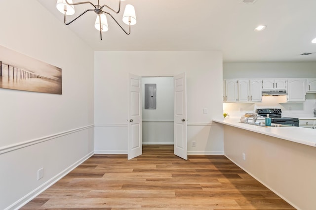 kitchen with black electric range, light hardwood / wood-style floors, electric panel, white cabinetry, and an inviting chandelier