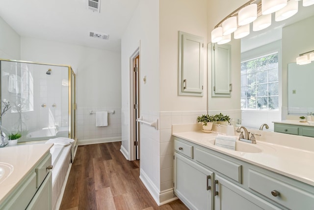 bathroom featuring vanity, walk in shower, tile walls, and hardwood / wood-style floors