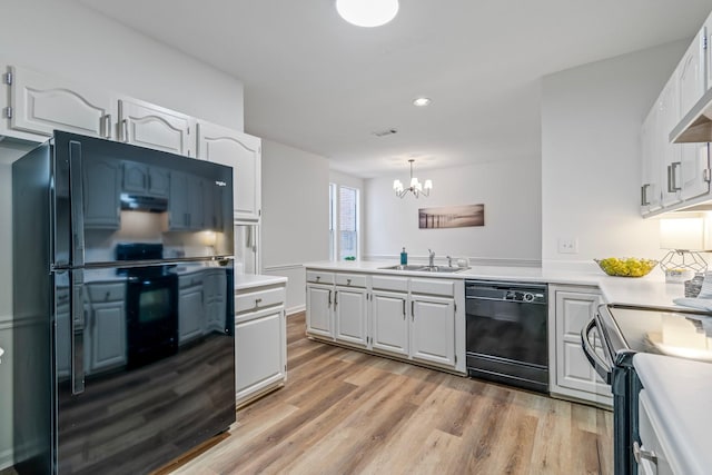 kitchen with black appliances, hanging light fixtures, white cabinetry, and sink