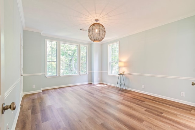 spare room with ornamental molding and light hardwood / wood-style floors