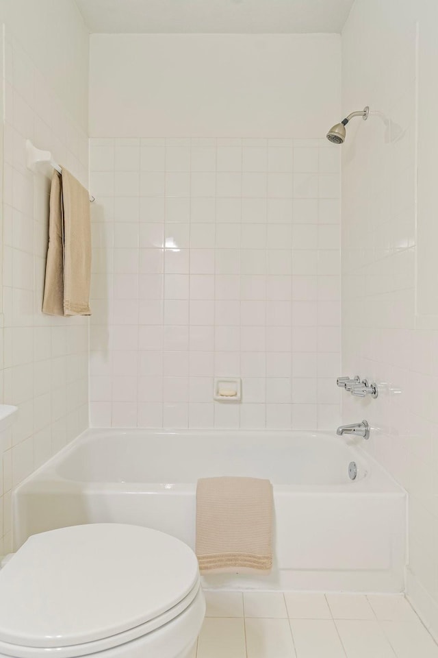 bathroom featuring toilet, tile patterned flooring, and tiled shower / bath