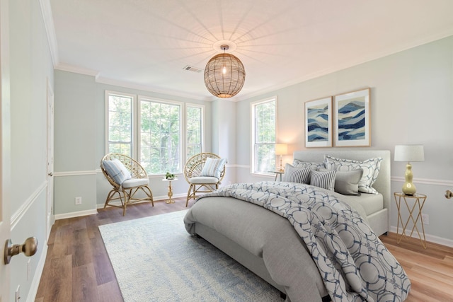 bedroom with crown molding and hardwood / wood-style flooring