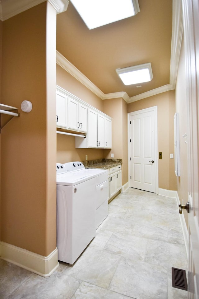 laundry room featuring washer and dryer, cabinets, and ornamental molding