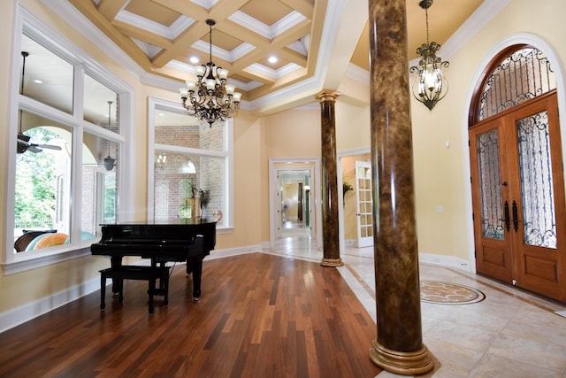 entryway with decorative columns, french doors, coffered ceiling, crown molding, and a notable chandelier