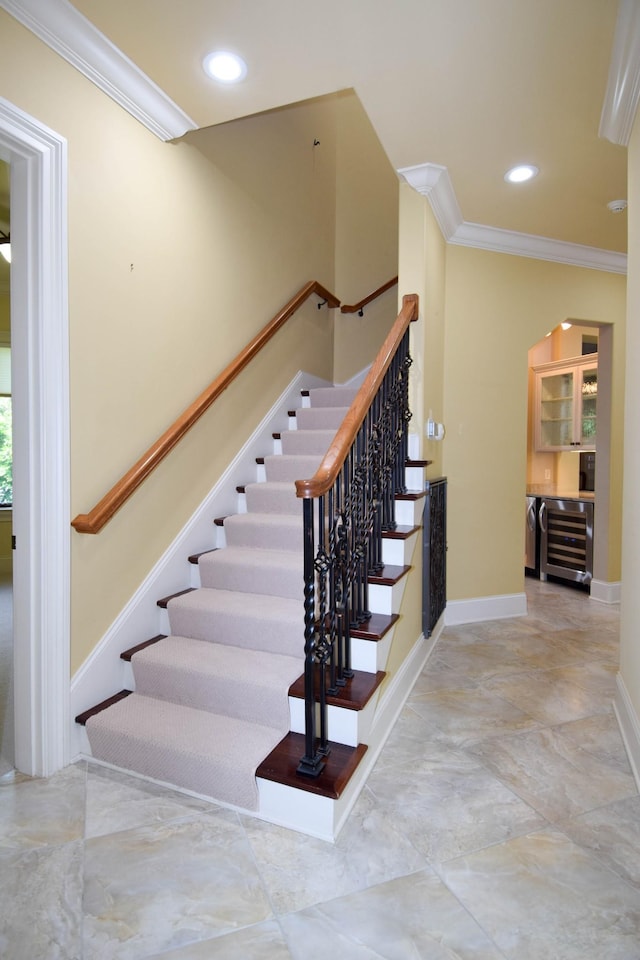 stairs featuring beverage cooler and crown molding