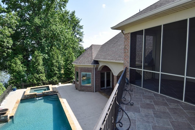 view of pool featuring an in ground hot tub, a sunroom, and a patio area