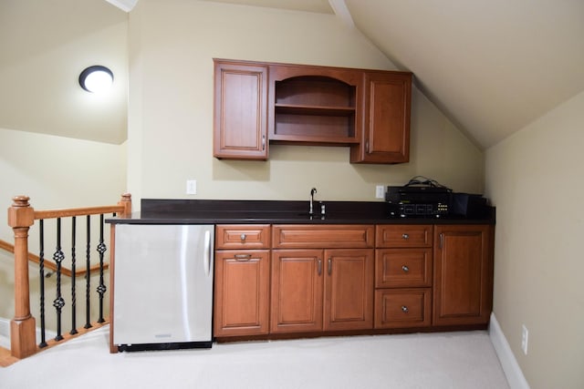 kitchen featuring sink, stainless steel fridge, light carpet, and lofted ceiling