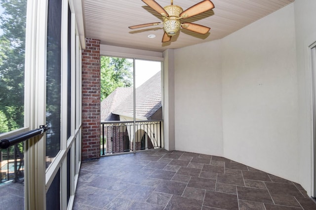 unfurnished sunroom with ceiling fan