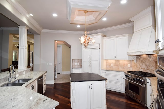 kitchen featuring sink, white cabinets, premium appliances, and pendant lighting