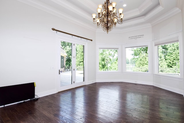 empty room with a raised ceiling, a chandelier, crown molding, dark wood-type flooring, and french doors