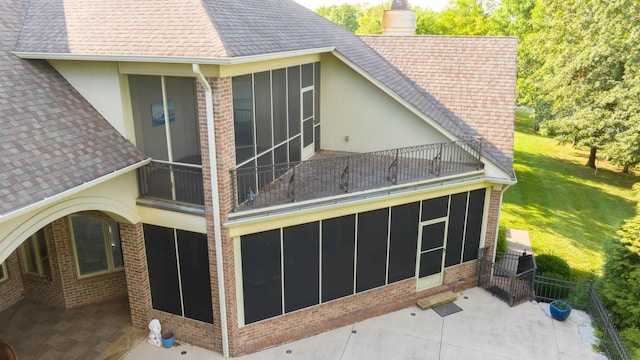 exterior space with a patio area, a sunroom, and a yard