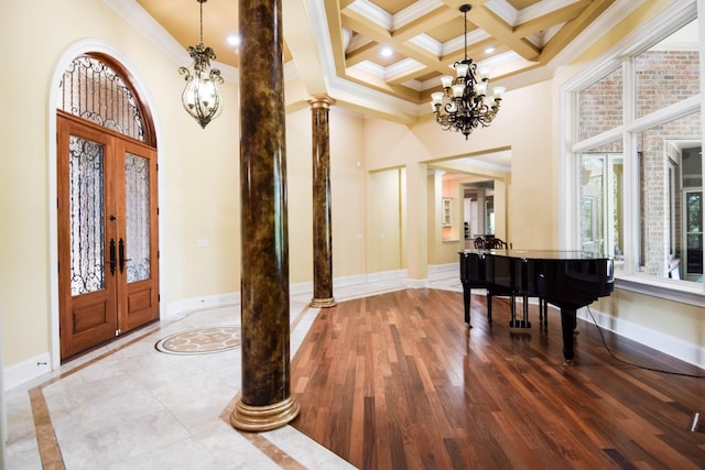 foyer featuring ornamental molding, french doors, coffered ceiling, and ornate columns