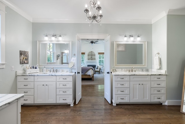 bathroom with ceiling fan with notable chandelier, hardwood / wood-style flooring, ornamental molding, and a wealth of natural light