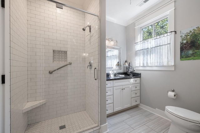 bathroom with a shower with door, vanity, and toilet