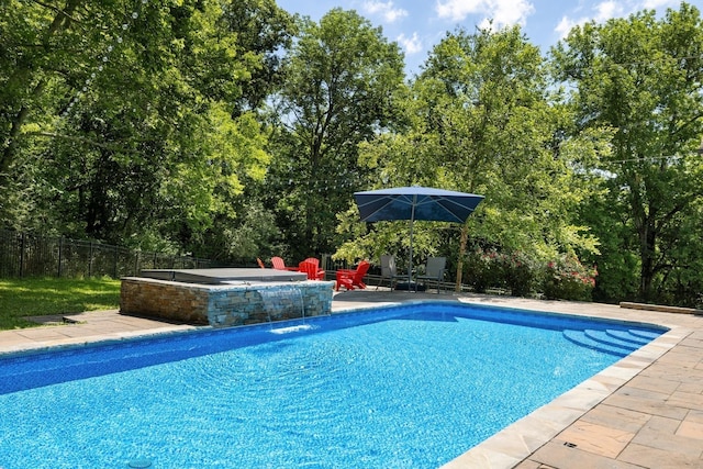 view of swimming pool with pool water feature, an in ground hot tub, and a patio area