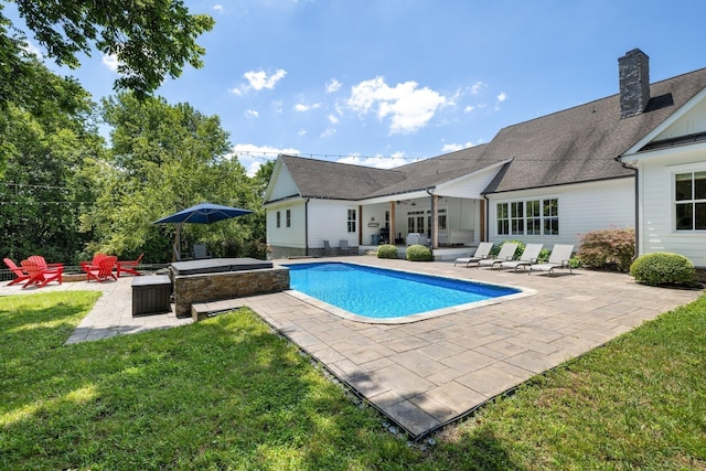 view of pool with a hot tub, ceiling fan, a patio, and a lawn