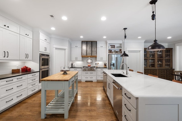 kitchen featuring a large island, hanging light fixtures, hardwood / wood-style floors, and appliances with stainless steel finishes