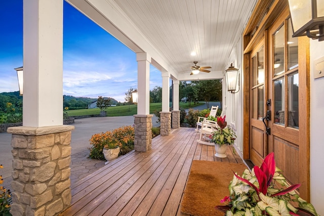 wooden deck with covered porch and ceiling fan