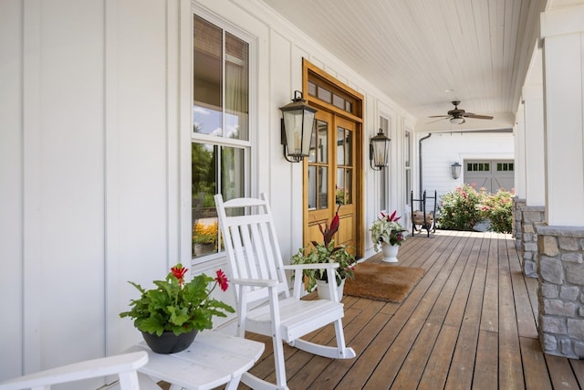 wooden terrace featuring covered porch and ceiling fan