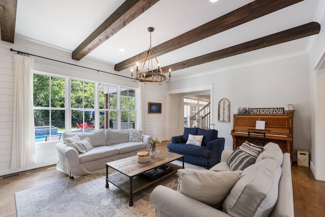 living room with wood-type flooring, a notable chandelier, and beam ceiling